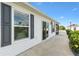 Exterior of home with a large concrete patio, hurricane shutters, and well-maintained landscaping at 6051 Chase Ct, The Villages, FL 32163