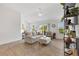 Bright living room features neutral tones, wood floors, and sliding doors to the outdoors at 6051 Chase Ct, The Villages, FL 32163