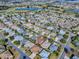 Aerial view showing a neighborhood featuring lakes, a golf course, and numerous homes at 610 Mallory Hill Dr, The Villages, FL 32162