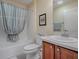 Full bathroom features a shower-tub combo, vanity with sink and wood cabinets at 610 Mallory Hill Dr, The Villages, FL 32162