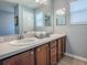 Bright bathroom features double sink vanity with wood cabinets and neutral countertops at 610 Mallory Hill Dr, The Villages, FL 32162