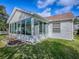 Side view of the home featuring a charming sunroom and well-maintained landscaping at 610 Mallory Hill Dr, The Villages, FL 32162