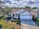 Aerial view of the house showcasing the manicured lawn, driveway, and mature landscaping at 610 Mallory Hill Dr, The Villages, FL 32162