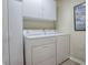 Convenient laundry room with appliances and white cabinets for storage at 610 Mallory Hill Dr, The Villages, FL 32162