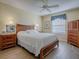 Comfortable main bedroom features wood furniture and a large window at 610 Mallory Hill Dr, The Villages, FL 32162