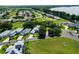 The aerial shot reveals a community with beautiful landscaping and mature trees near the water at 6250 Sailboat Ave, Tavares, FL 32778