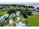 Aerial view of a charming neighborhood, with mature trees and a glimpse of a lake in the background at 6250 Sailboat Ave, Tavares, FL 32778