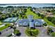 An aerial view showcasing a community clubhouse, pool, tennis courts, landscaping, and a lake view at 6250 Sailboat Ave, Tavares, FL 32778