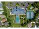 This aerial photo features a community clubhouse, pool, tennis courts, and ample parking at 6250 Sailboat Ave, Tavares, FL 32778