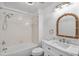 Bright white bathroom featuring a tub/shower combo and a lovely mirror with rope accent at 6250 Sailboat Ave, Tavares, FL 32778