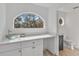 Modern bathroom featuring a unique vessel sink and vanity, plus arched window view to trees at 6250 Sailboat Ave, Tavares, FL 32778