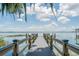 Scenic view down the wooden community dock showcasing seating areas and the calm waters of the lake at 6250 Sailboat Ave, Tavares, FL 32778