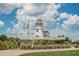 The community's decorative lighthouse is set on a hill with manicured landscaping under a partly cloudy sky at 6250 Sailboat Ave, Tavares, FL 32778