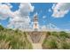 The community's decorative lighthouse is set on a hill with landscaping under a partly cloudy sky at 6250 Sailboat Ave, Tavares, FL 32778