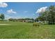 A scenic view of a green common area with a bench, walking path, and neighborhood homes at 6250 Sailboat Ave, Tavares, FL 32778