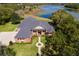 Aerial view of a brick home featuring a lush lawn, mature trees, and a picturesque lake at 631 Old Mount Dora Rd, Eustis, FL 32726