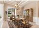 Charming dining room featuring travertine floors, a decorative chandelier, and a large window at 631 Old Mount Dora Rd, Eustis, FL 32726