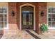 Elegant arched doorway featuring double doors with decorative glass, flanked by sidelights and sconce lighting at 631 Old Mount Dora Rd, Eustis, FL 32726