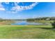 Scenic view of the lake, featuring a wide expanse of grass in the foreground and a beautiful blue sky with fluffy clouds at 631 Old Mount Dora Rd, Eustis, FL 32726