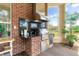 Outdoor kitchen featuring a stainless steel grill, granite countertop and a stainless steel vent hood at 631 Old Mount Dora Rd, Eustis, FL 32726