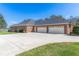 Back of home showing large brick home, expansive driveway and three-car garage facing the waterfront at 631 Old Mount Dora Rd, Eustis, FL 32726