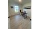 A bright room features a desk with a chair, wood-look flooring, and white walls at 654 Nw 9Th Ave, Webster, FL 33597