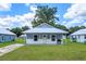 Charming blue cottage home featuring a metal roof, covered porch, and well-maintained front lawn at 654 Nw 9Th Ave, Webster, FL 33597