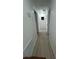 A hallway features wood-look flooring and white walls leading to other rooms at 654 Nw 9Th Ave, Webster, FL 33597