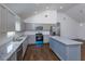 Bright kitchen with stainless steel appliances, granite counters, and gray cabinetry at 654 Nw 9Th Ave, Webster, FL 33597