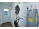 Bright laundry room with a stacked washer and dryer, plus a modern water heater, and exterior door at 654 Nw 9Th Ave, Webster, FL 33597