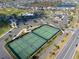 Aerial shot showcasing the community tennis courts, surrounded by lush landscaping and residential homes at 6576 Merrill Ln, The Villages, FL 34762