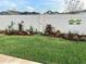 A manicured backyard with a well-kept lawn and decorative flower beds at 6576 Merrill Ln, The Villages, FL 34762