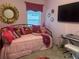 Bright bedroom features decorative pillows, gold mirror, TV, and keyboard at 6576 Merrill Ln, The Villages, FL 34762