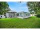 Exterior view of a home with a screened patio and a full view of the enclosed pool at 726 Grand Vista Trl, Leesburg, FL 34748