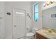 Bathroom with a white door, toilet, vanity with sink, and a small window at 726 Grand Vista Trl, Leesburg, FL 34748