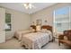 Well-lit bedroom featuring twin beds, a ceiling fan, a window with blinds, and a comfortable chair at 726 Grand Vista Trl, Leesburg, FL 34748