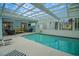 Inviting indoor pool with a glass roof, creating a bright and enjoyable space for relaxation and recreation at 726 Grand Vista Trl, Leesburg, FL 34748