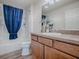 Bathroom showcasing a shower with blue curtain, vanity with sink, and a well-lit space at 796 Elliott Ave, The Villages, FL 32163