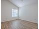 Bedroom featuring vaulted ceiling, window and light wood-look flooring at 796 Elliott Ave, The Villages, FL 32163