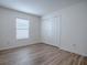 Bedroom features light wood-look flooring, window and closet with bi-fold doors at 796 Elliott Ave, The Villages, FL 32163