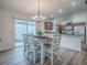 Bright dining area features sliding glass doors, chandelier, and seamlessly connects to the kitchen at 796 Elliott Ave, The Villages, FL 32163