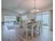 Inviting dining area with a modern chandelier, white furniture, and access to the bright living area at 796 Elliott Ave, The Villages, FL 32163