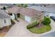 An aerial view showcases a lovely single-story home with a two-car garage, bordered by lush landscaping and a driveway at 796 Elliott Ave, The Villages, FL 32163