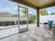 Relaxing screened lanai with stone flooring and comfortable chair overlooking the lush backyard at 796 Elliott Ave, The Villages, FL 32163