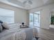 Bright main bedroom featuring a tray ceiling and sliding glass door to the patio at 796 Elliott Ave, The Villages, FL 32163