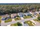 An aerial view of homes with green lawns, driveways, and mature trees in the backyard at 8373 Se 177Th Bartram Loop, The Villages, FL 32162