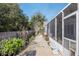 A stone walkway next to a screened in lanai surrounded by decorative rock and landscaping at 8373 Se 177Th Bartram Loop, The Villages, FL 32162