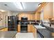 Spacious kitchen featuring stainless steel appliances, wood cabinets, and dark countertops at 8373 Se 177Th Bartram Loop, The Villages, FL 32162