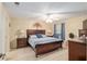 Cozy main bedroom with neutral walls, wood furniture, and fan at 8373 Se 177Th Bartram Loop, The Villages, FL 32162