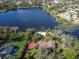 Beautiful lakefront home with a private beach, lush landscaping, and a red driveway at 840 2Nd St, Clermont, FL 34711